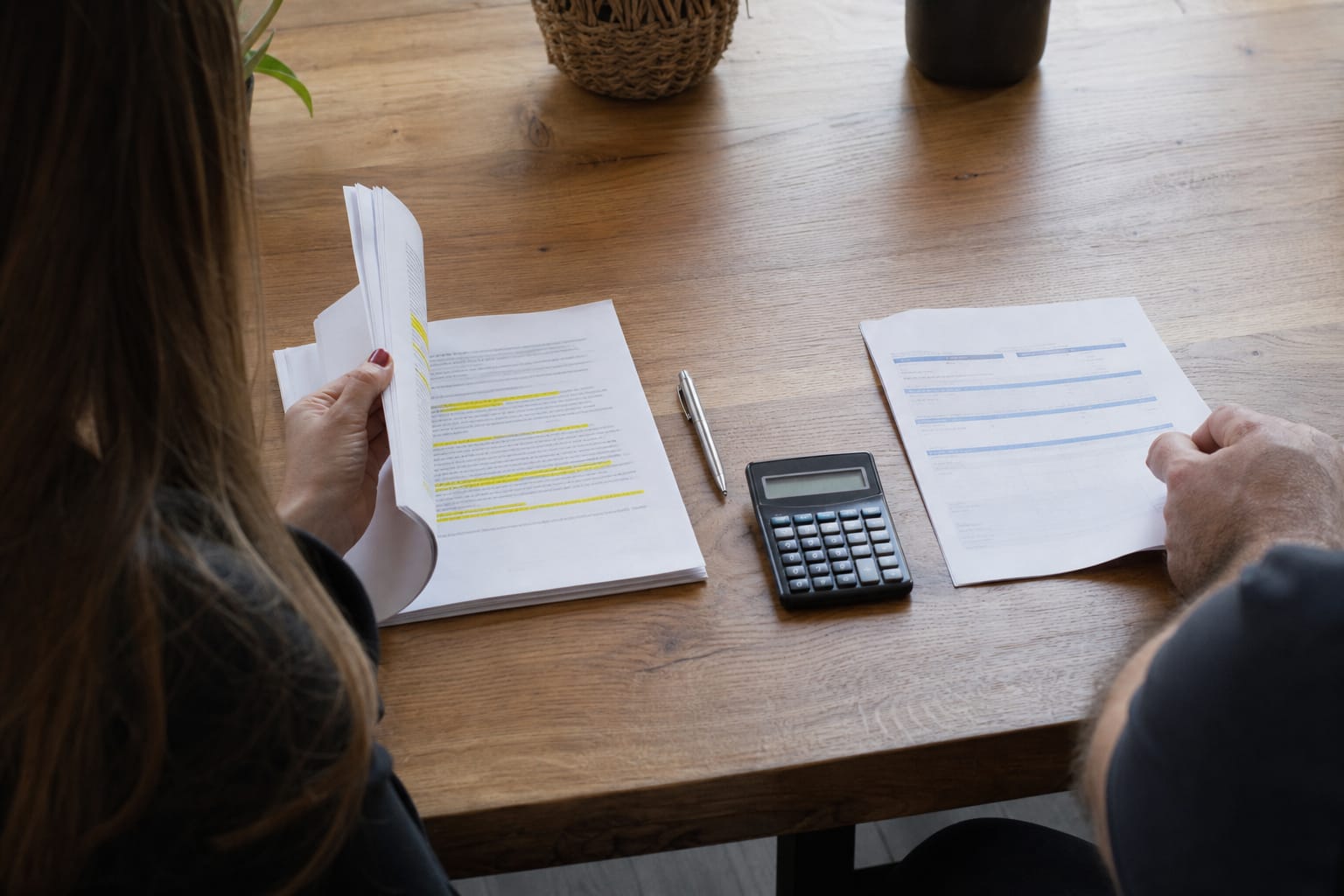 Multi-page agency scope of work beside a one-page software subscription summary, with a pen and calculator between them.