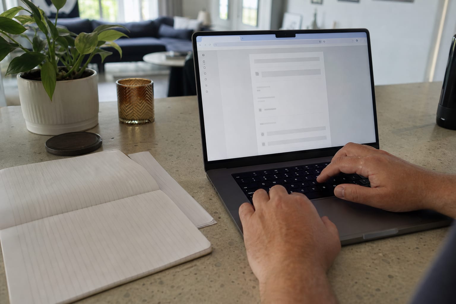 Hands at a keyboard beside a notebook listing monthly software costs, browser open to a billing page